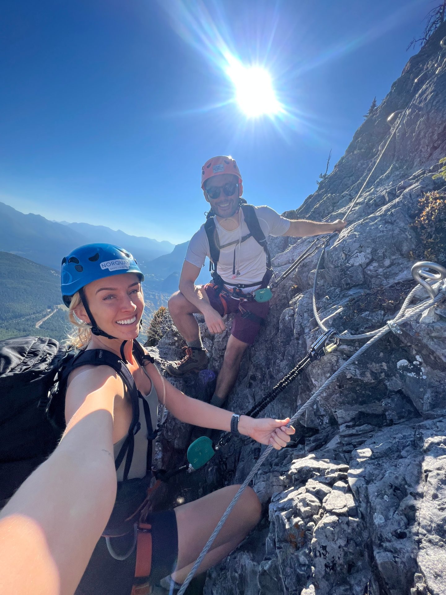 A man and a woman attached to the Mount Norquay via ferrata in Banff, Canada - Canada Road Trip Itinerary