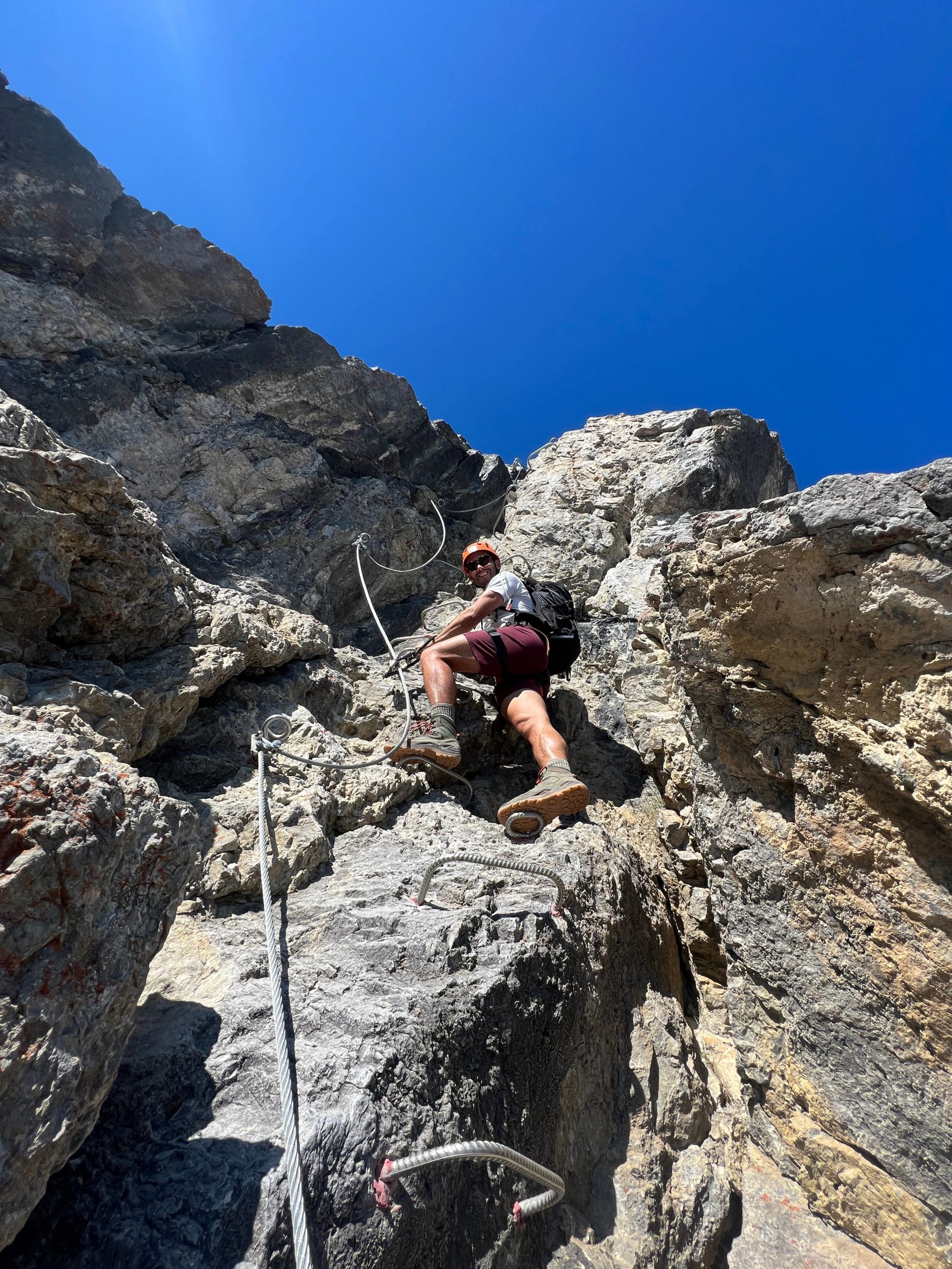 A man scrabbling on the Mount Norquay via ferrata in Banff - Canada Road Trip Itinerary