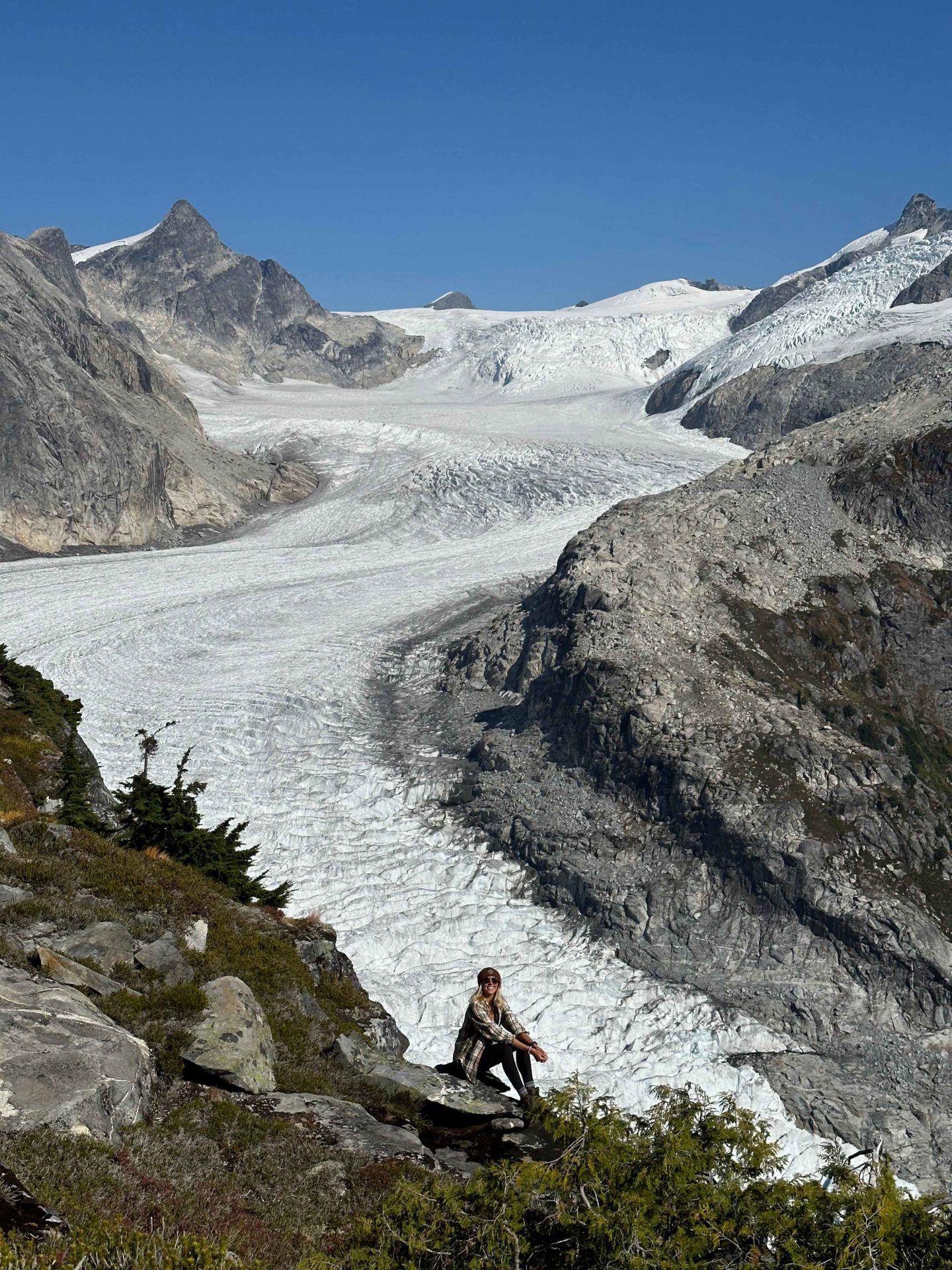 Zanna van Dijk sits in front of a glacier on Vancouver Island - Canada Road Trip Itinerary