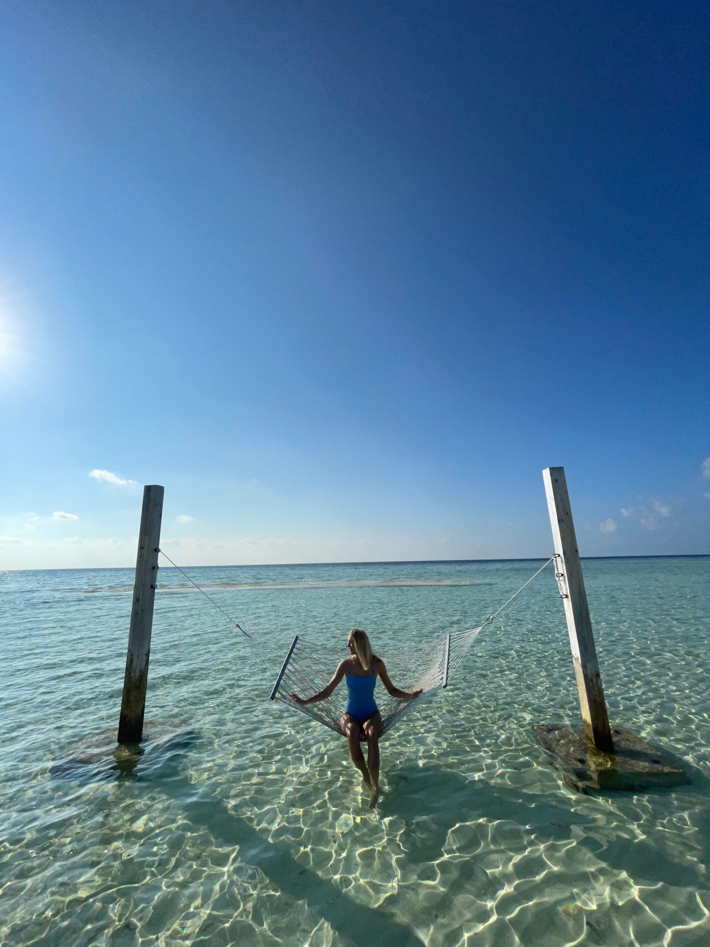 Zanna van Dijk sat on a hammock in the sea in the Maldives