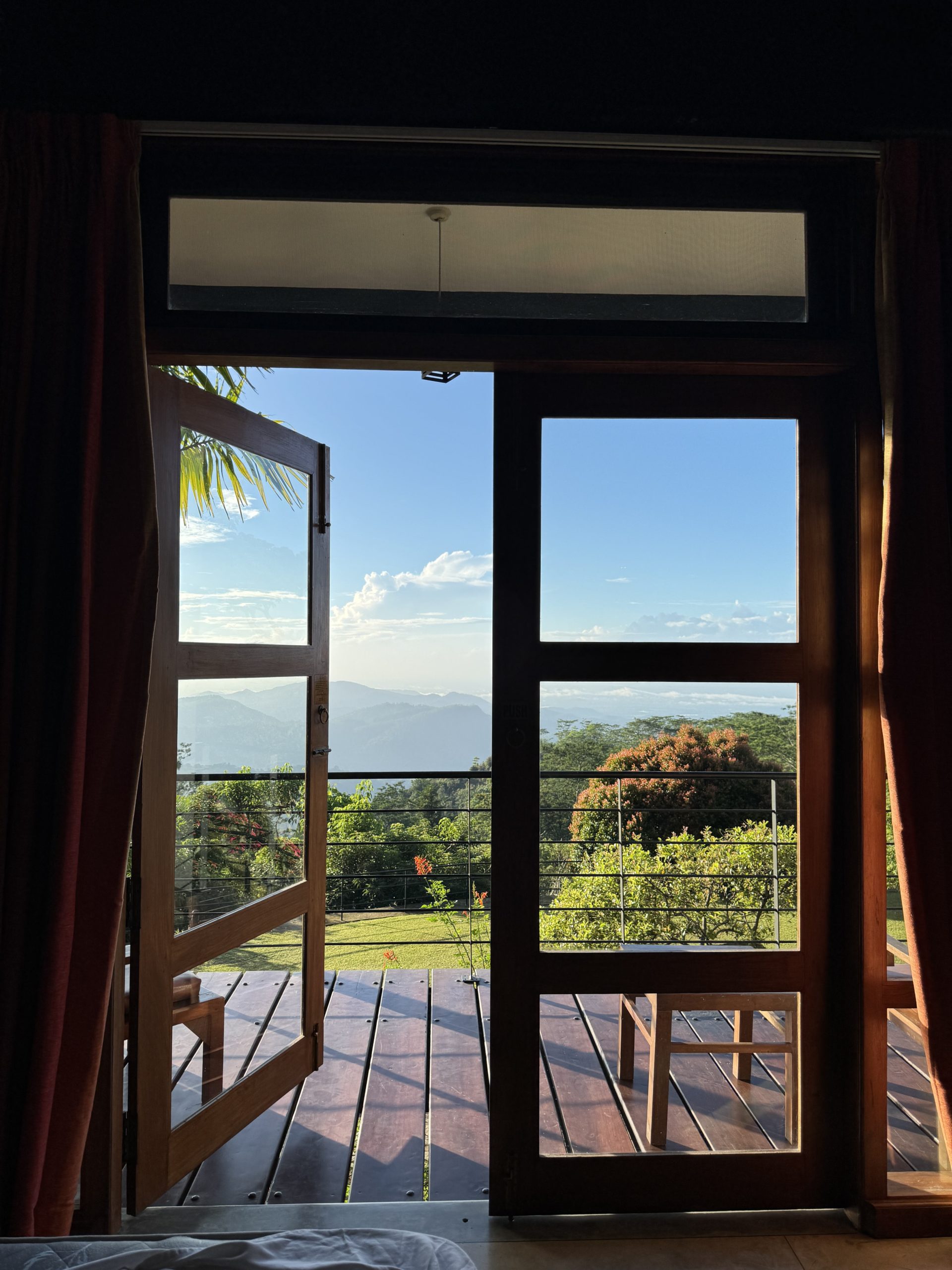 A view of the Sri Lankan skyline looking through doors that open onto a balcony