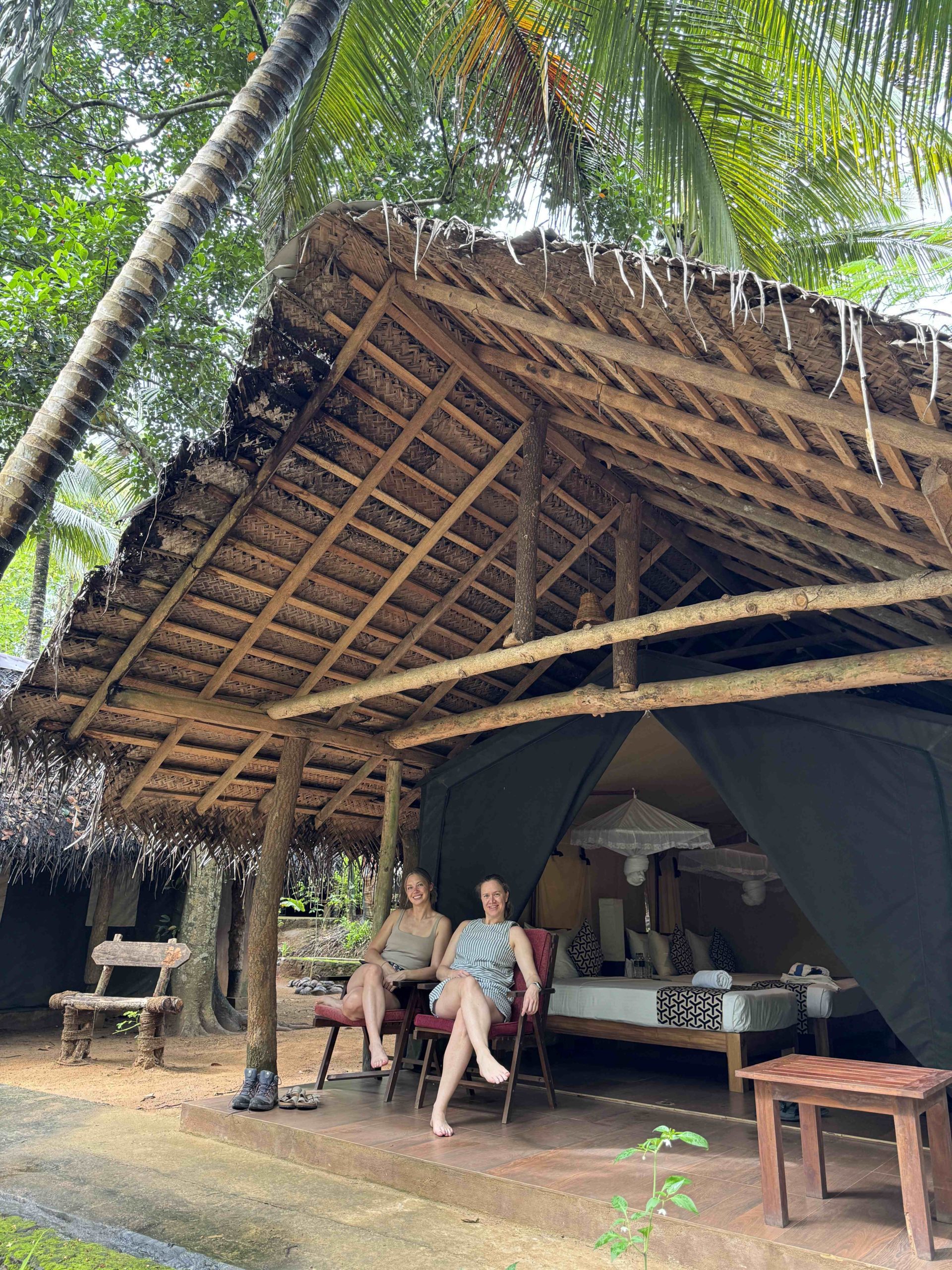 Two women sit in the entrance of a hut in Sri Lanka