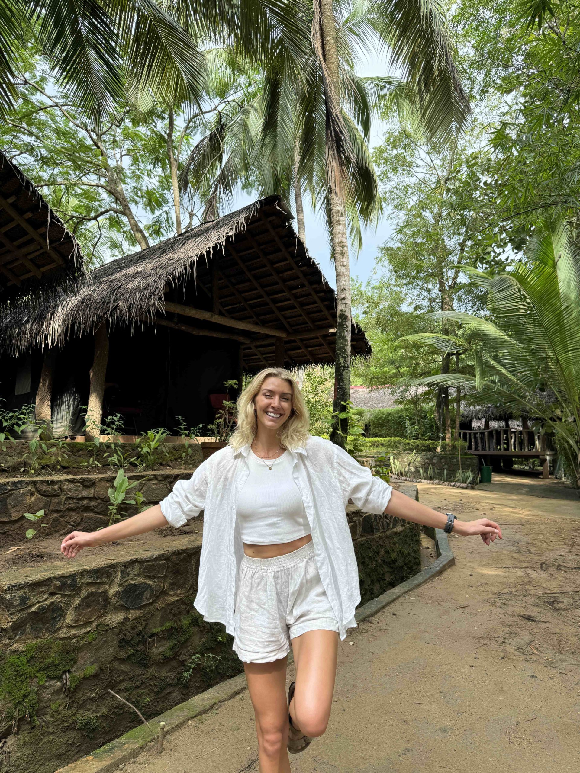 Zanna van Dijk stood in front of a straw-topped hut in Sri Lanka