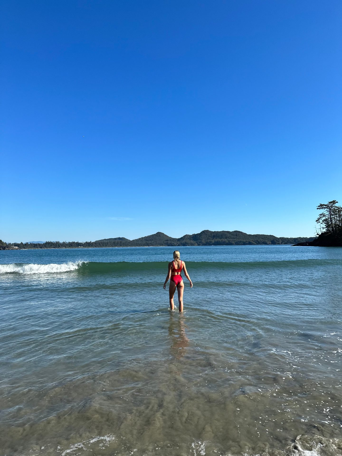 Zanna van Dijk walking into the sea in Tofino on Vancouver Island